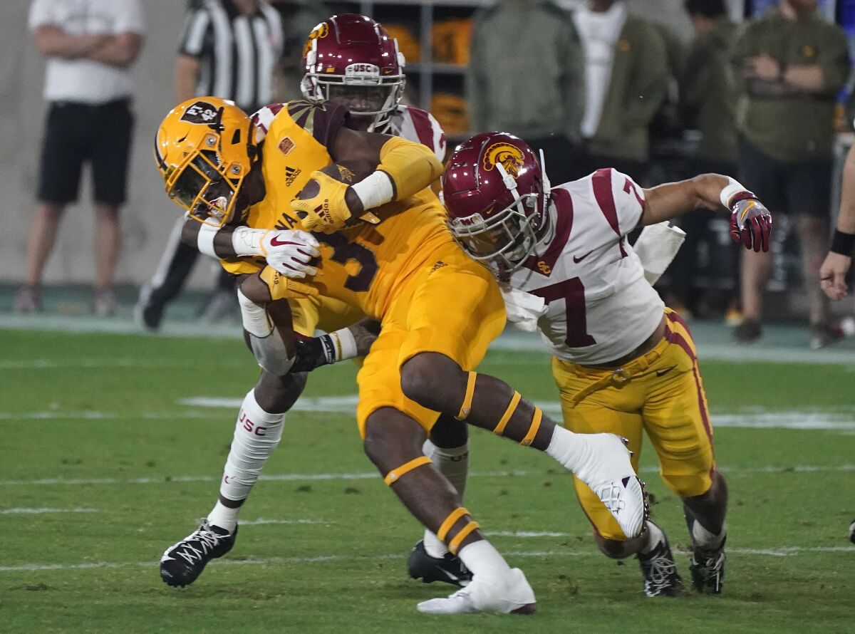 Arizona State running back Rachaad White is wrapped up by USC's Calen Bullock and Chase Williams.