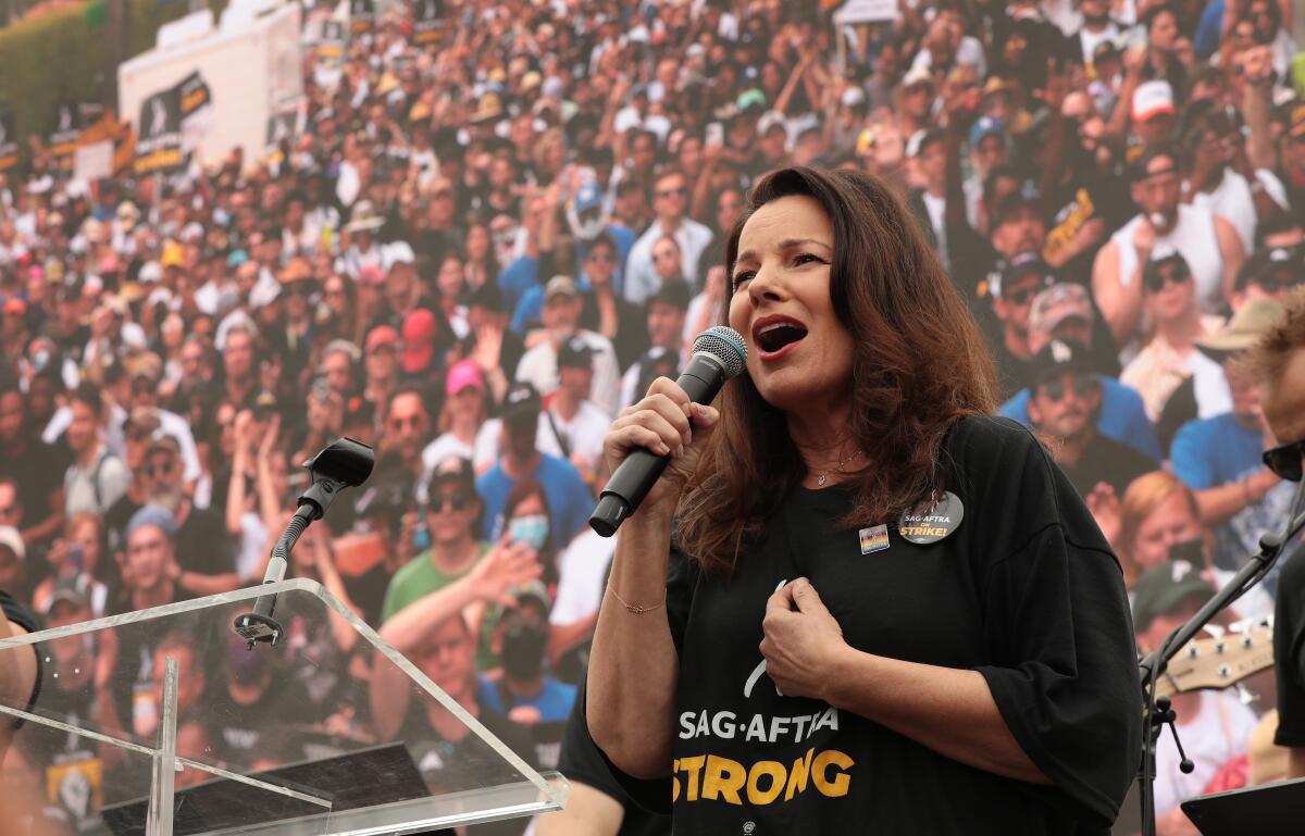 SAG-AFTRA President Fran Drescher speaks into a microphone while addressing a crowd.