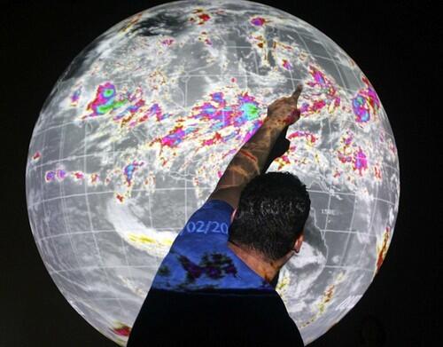 Imiloa Museum tour associate, Keoki Bezilla, points out hurricane formations on the "Science on a Sphere" exhibit in Hilo, Hawaii. For visitors to Hawaii looking for something they can't see from the beach or golf course, this unconventional museum tells the story of how the star-filled skies guided discoverers to the islands.