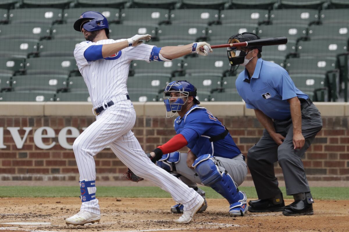 FILE - In his July 15, 2020, file photo, Chicago Cubs' Kris Bryant, left, hits a one-run single during an intrasquad baseball game at Wrigley Field in Chicago. As baseball attempts to play a shortened 60-game regular season amid a coronavirus pandemic, there is some concern that home plate could become a hot spot for transmission. (AP Photo/Nam Y. Huh, File)