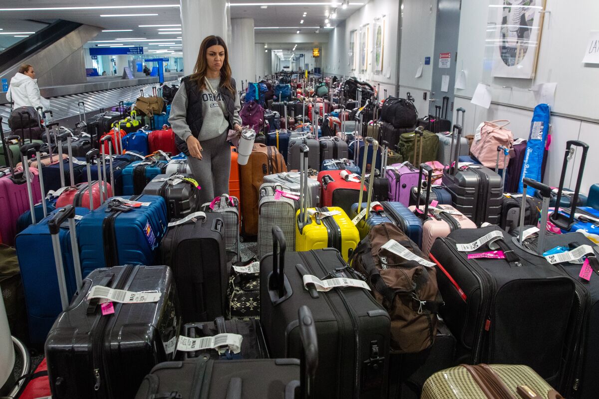 A woman stands amid suitcases in an airport