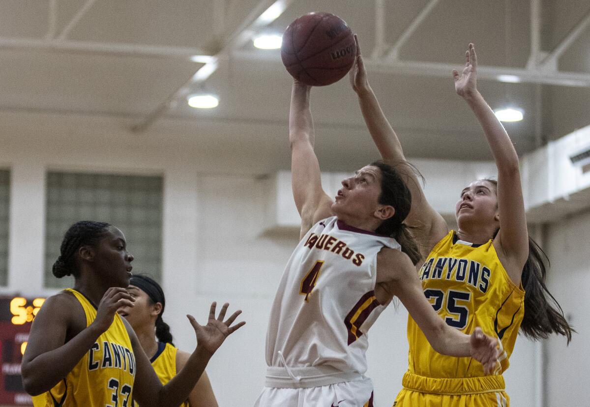 Glendale Community College guard Vicky Oganyan grabs a rebound between College of the Canyons' Diamyn Davis and Cristian Patron, right, during a game Feb. 12.