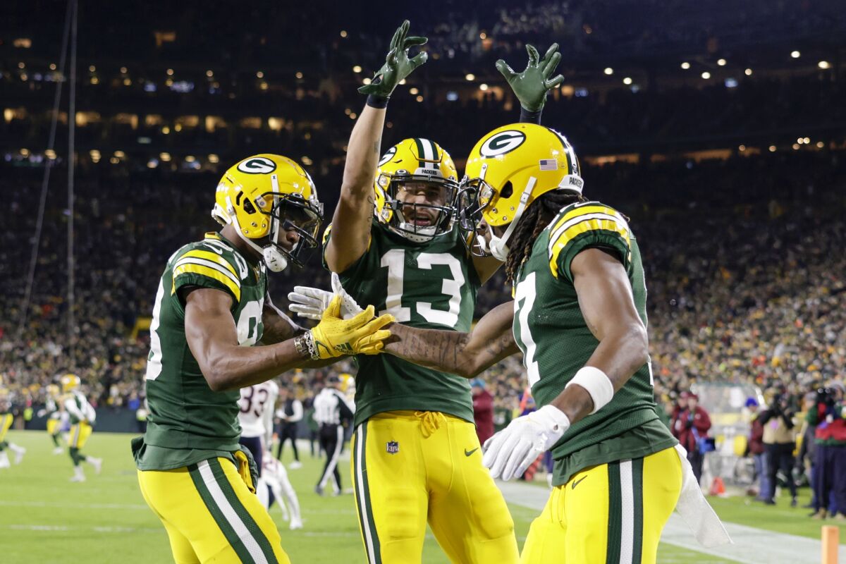 Green Bay Packers' Davante Adams celebrates his touchdown catch with Marquez Valdes-Scantling and Allen Lazard (13) during the first half of an NFL football game against the Chicago Bears Sunday, Dec. 12, 2021, in Green Bay, Wis. (AP Photo/Matt Ludtke)