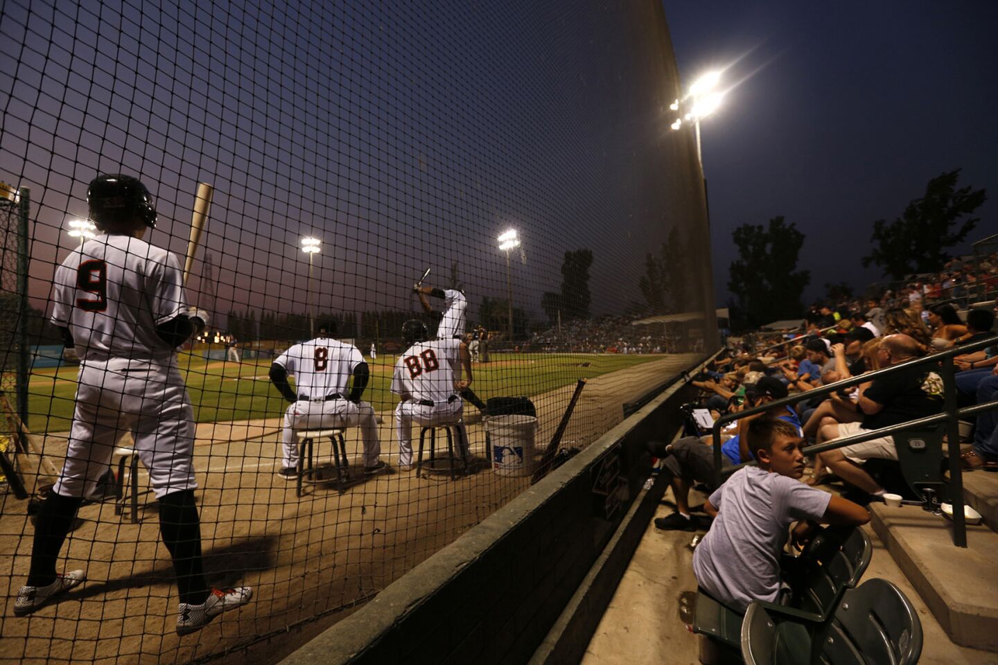Bakersfield Blaze player Braden Bishop, left, prepares for his at-bat while fans take in one of their last games at Sam Lynn Ballpark. When the season ends and the team folds, it will bring to close 75 years of baseball in the Central California city.