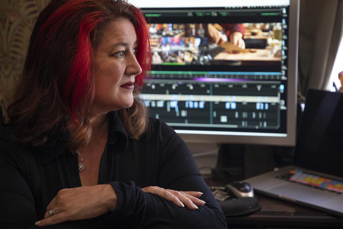 A woman poses in front of a computer.