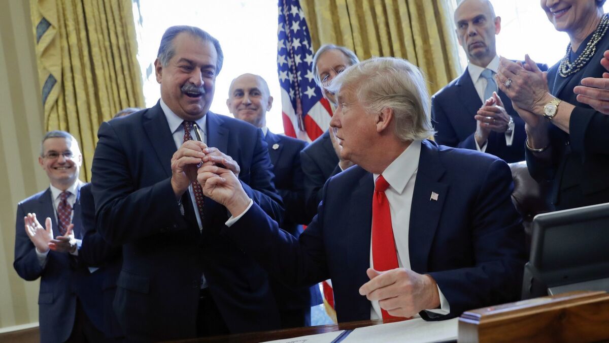 After signing an executive order in 2017, President Trump hands a pen to Andrew Liveris, then CEO of Dow Chemical. Soon after, the EPA reversed a ban on the pesticide chlorpyrifos, a Dow product.