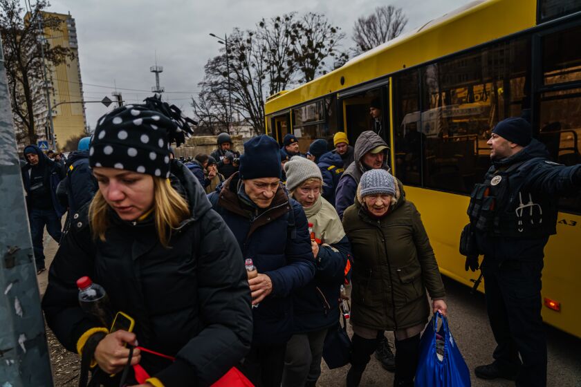 IRPIN, UKRAINE -- MARCH 6, 2022: Local residents arrive evacuation busses after their town was bombarded with Russian artillery fire in Irpin, Ukraine, Sunday, March 6, 2022. (MARCUS YAM / LOS ANGELES TIMES)