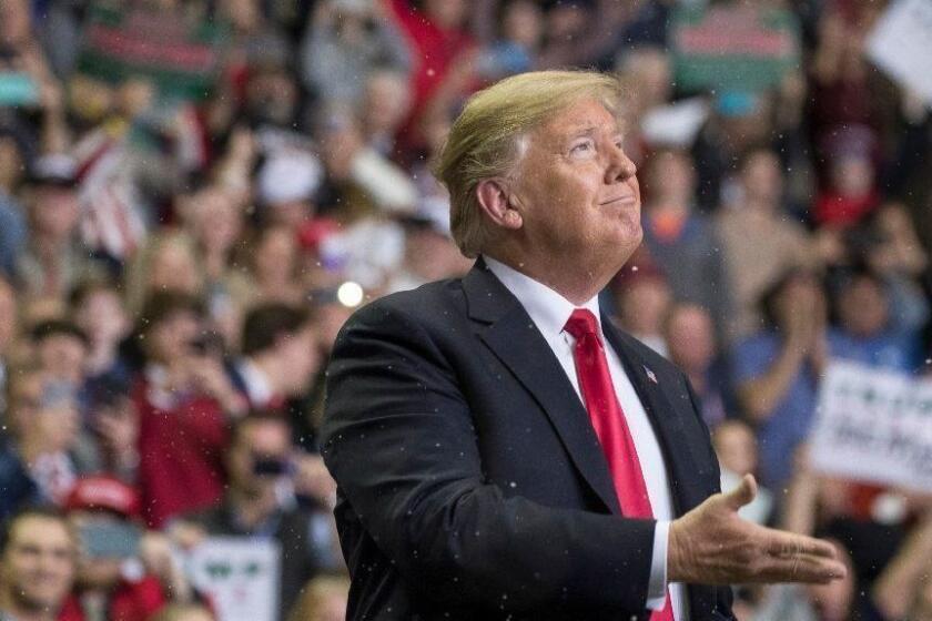 President Donald Trump looks at the fake snow that was dropping from the ceiling as he arrives to speak at a rally for Sen. Cindy Hyde-Smith, R-Miss., at the Mississippi Coast Coliseum, Monday, Nov. 26, 2018, in Biloxi, Miss. (AP Photo/Alex Brandon)