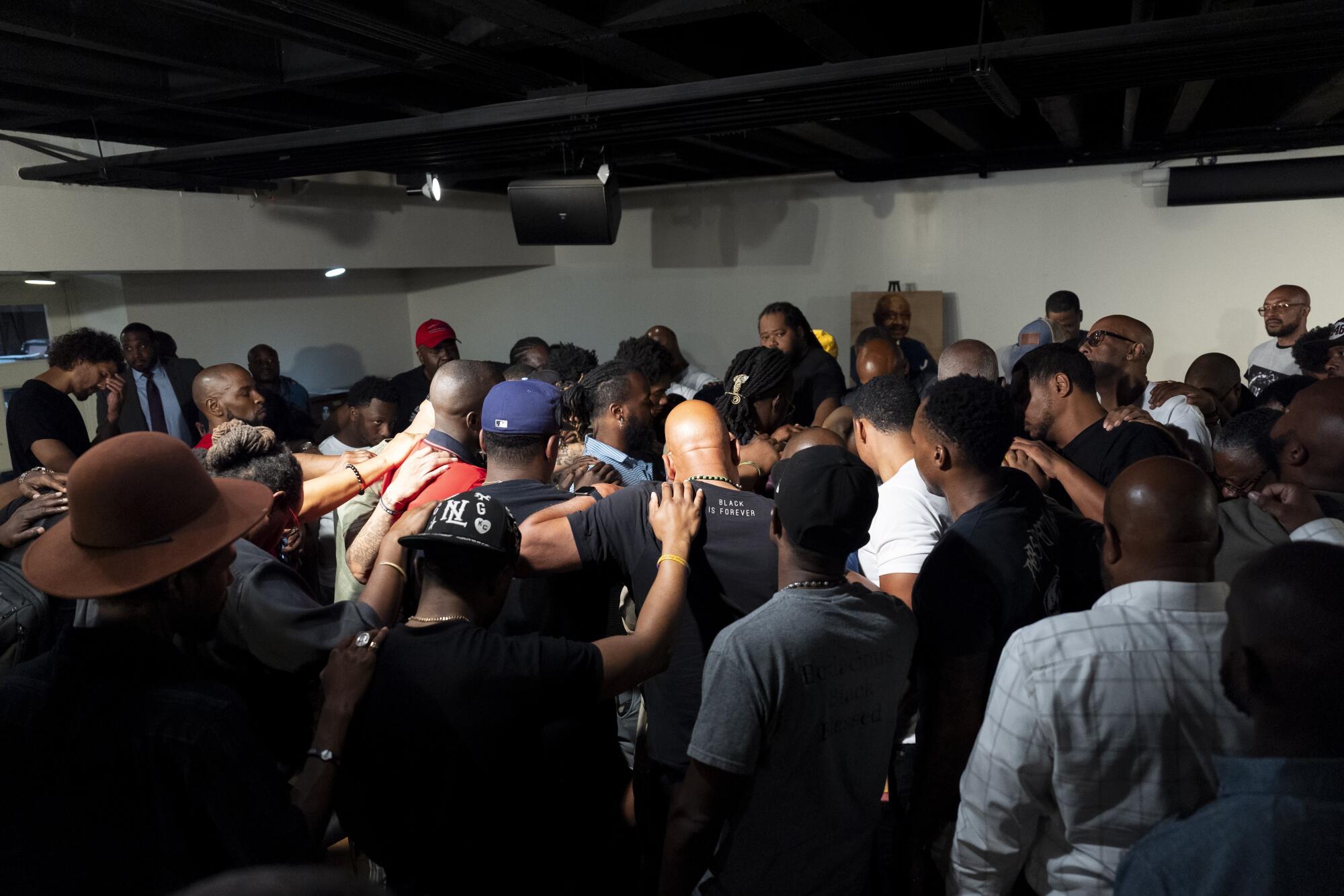 People attending a meeting form a circle for prayer