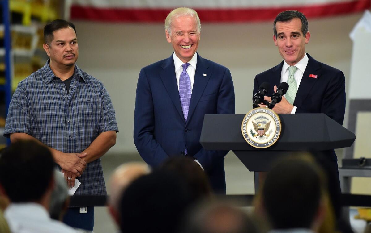 Vice President Joe Biden laughs as Mayor Eric Garcetti speaks to workers--including longtime employee Rigo Hernandez (left)--at Bobrick Washroom Equipment in Los Angeles in July. Biden came to discuss increasing the minimum wage.