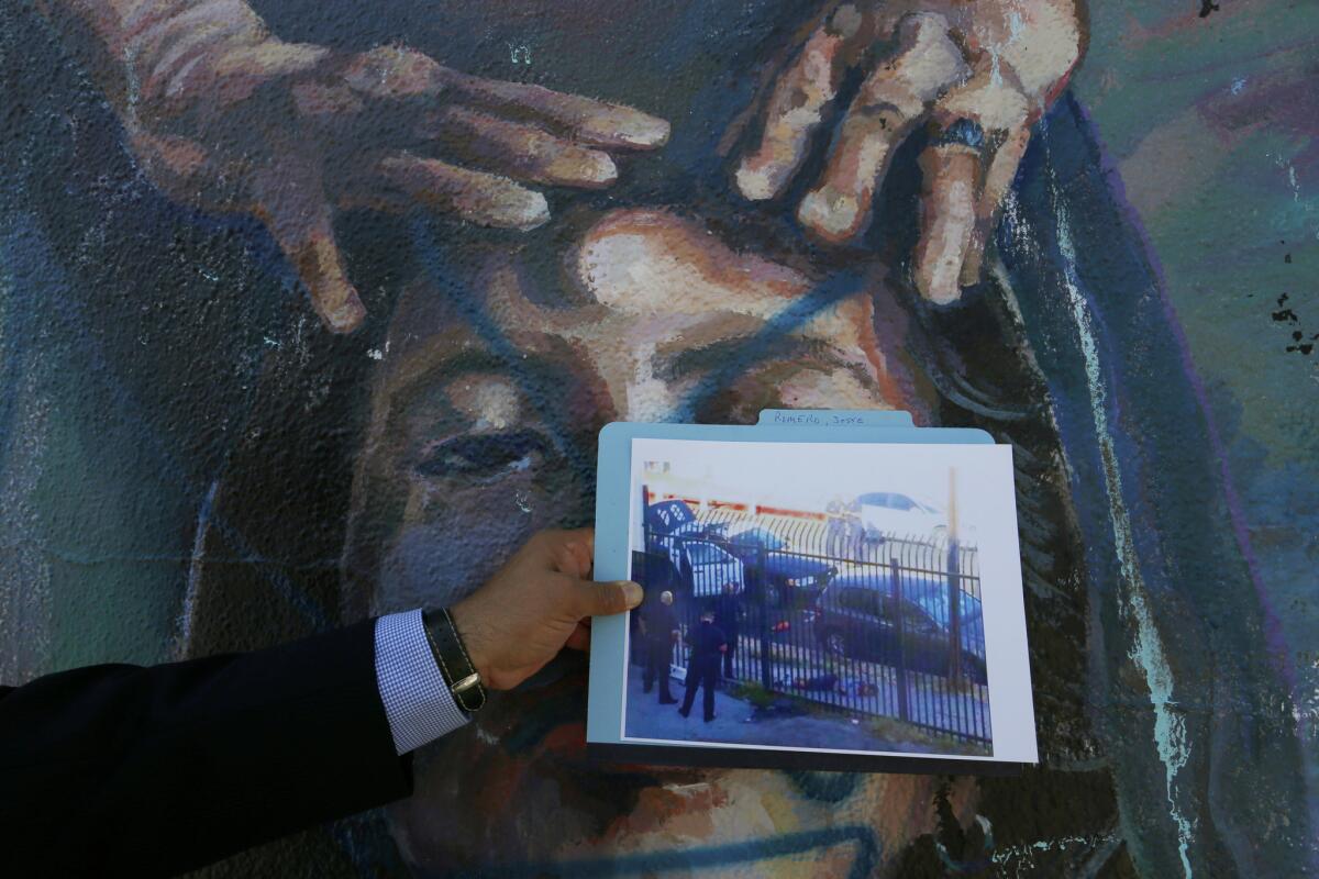 An attorney for Jesse Romero's mother holds a photo of Romero 14, after he was shot during a police chase in Boyle Heights.