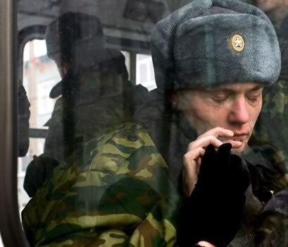 A young Russian miltary recruit shows his emotions as he sits aboard a bus that will take him from the call-up center in Kemerovo, Western Siberia, to active duty. The soldiers can be sent anywhere in the country, which means they could be going thousands of miles from their homes.