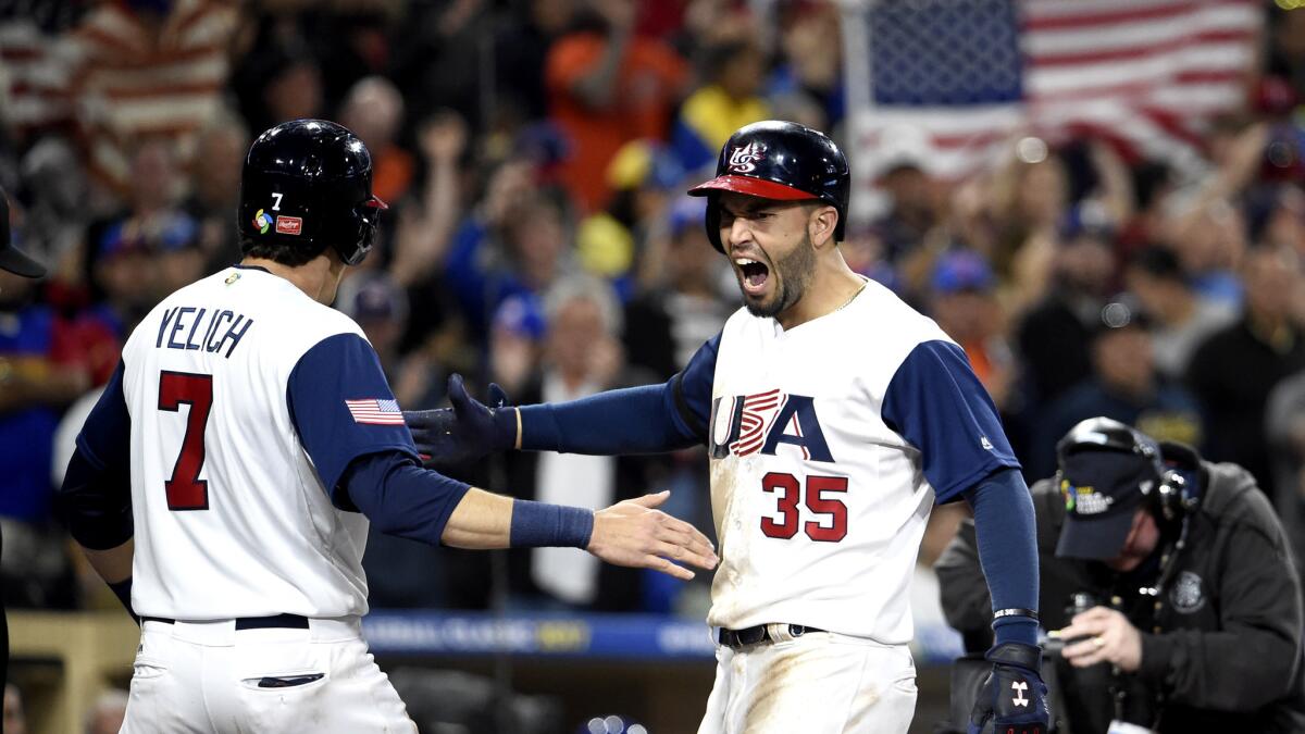 U.S. first baseman Eric Hosmer celebrates with teammate Christian Yelich after hitting a two-run home run against Venezuela in eighth inning Wednesday night.