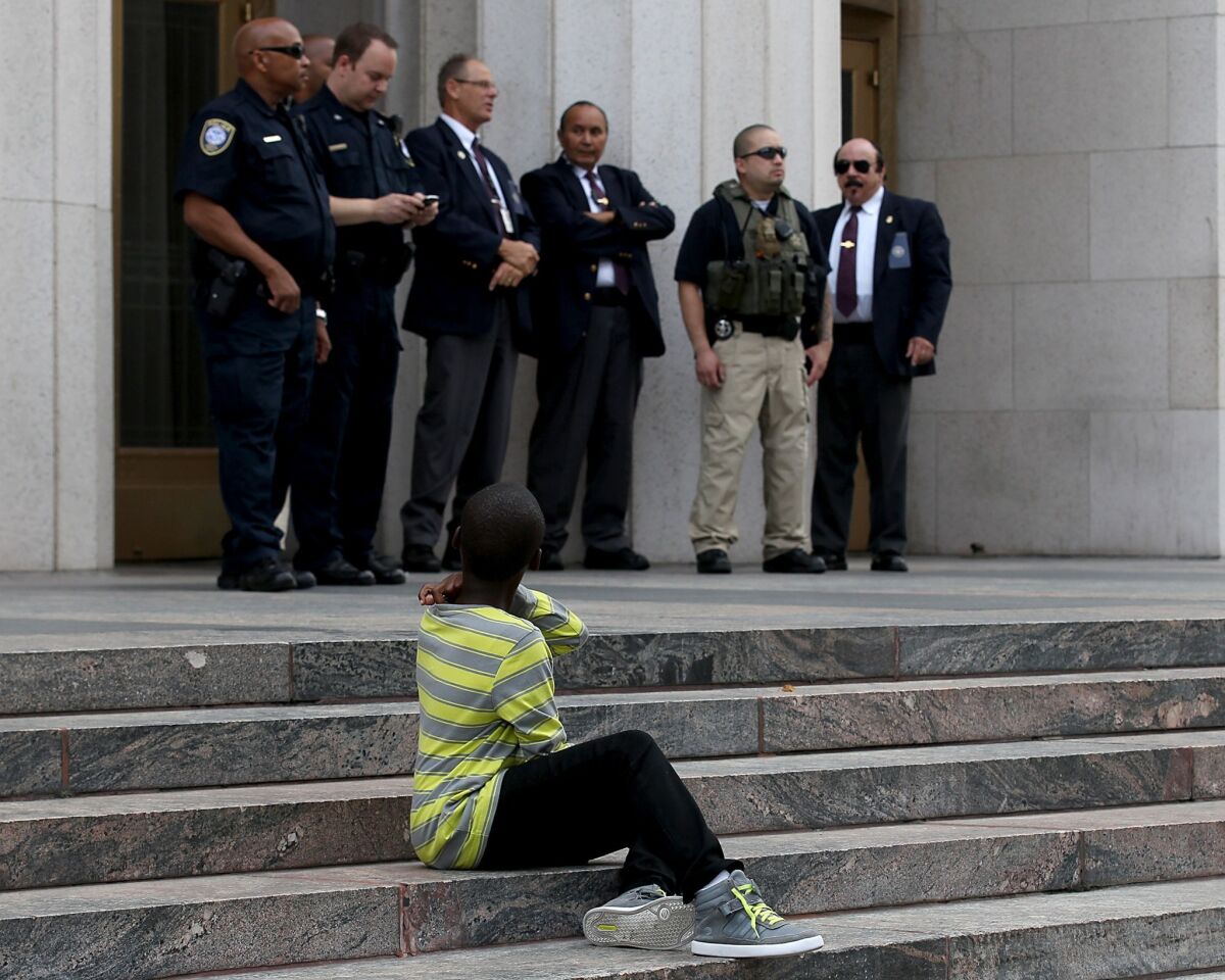 A child looks at security personnel guarding the federal courthouse during a "justice for Trayvon Martin" protest and march in downtown Los Angeles. About 400 people participated in the march.