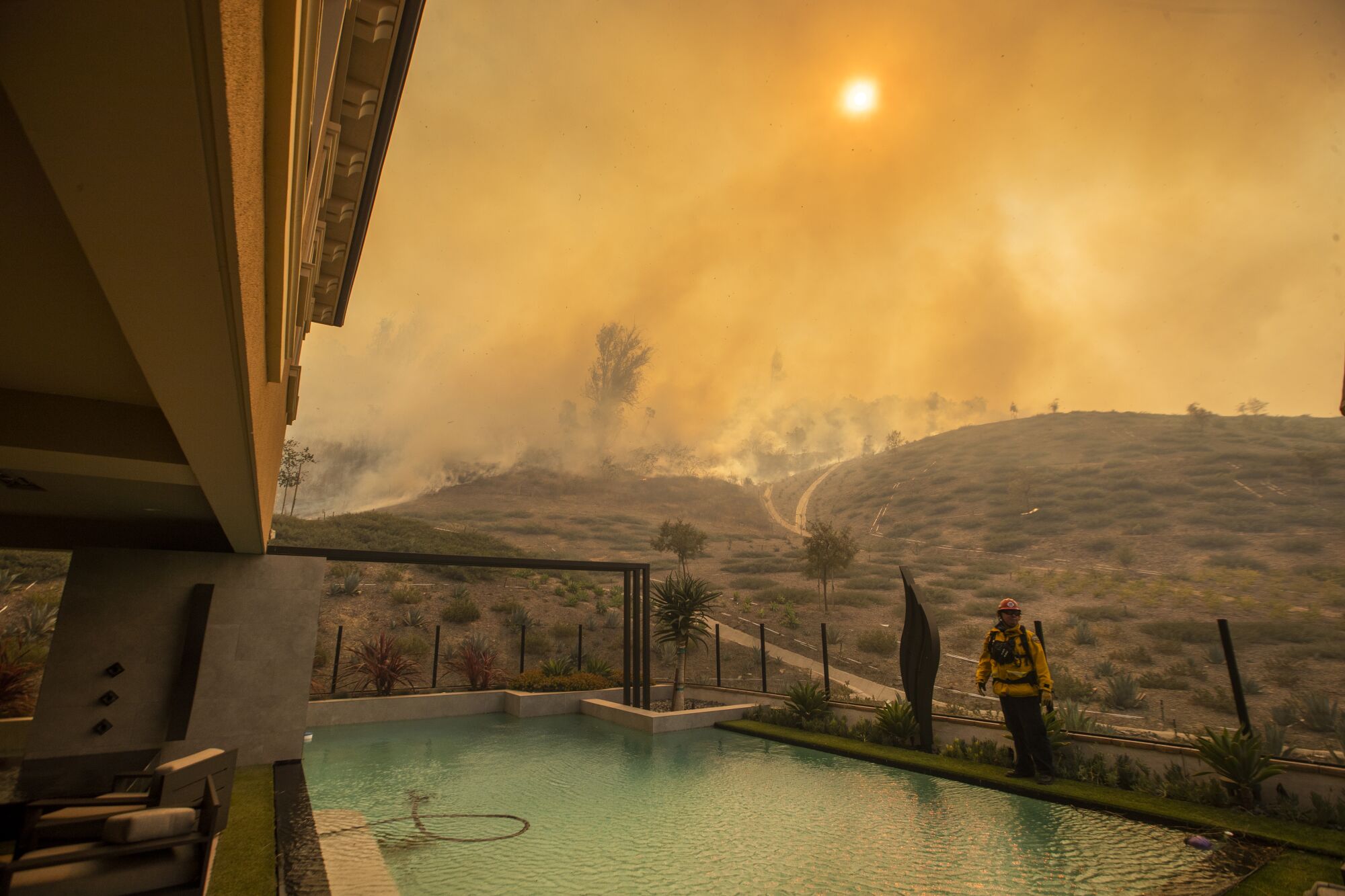 The Silverado fire burns close to a home Monday in Irvine's Orchard Hills neighborhood.