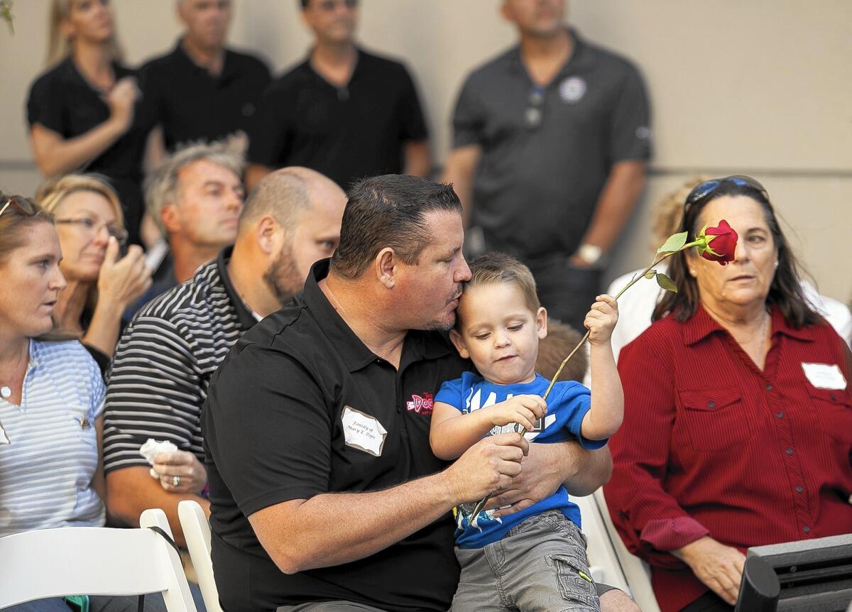 Danny Harris hugs his son River, 3, during an event Thursday at Hoag Hospital’s Tree of Life memorial for organ donors. The family was there to honor River’s mother, Mary Pope, who died last year. Eight people whose organs were donated were honored.