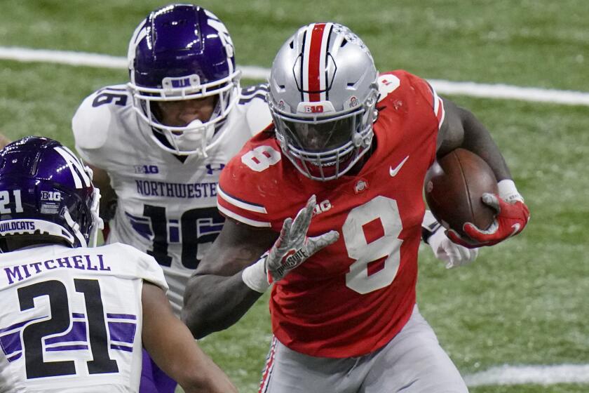 Ohio State running back Trey Sermon (8) runs with the ball as Northwestern defensive back Cameron Mitchell.
