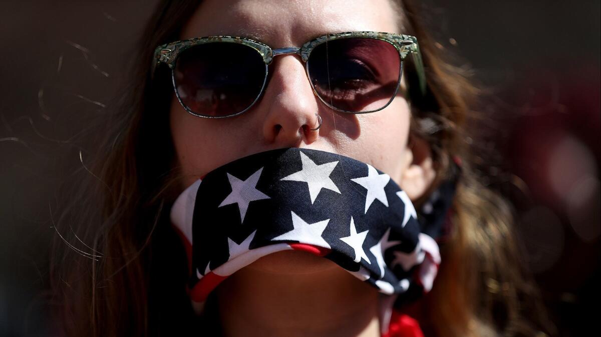 A protester wears a patriotic bandana over her mouth during a march and rally to support women's health programs and protest the global gag rule on March 8, 2017, in Washington, D.C.