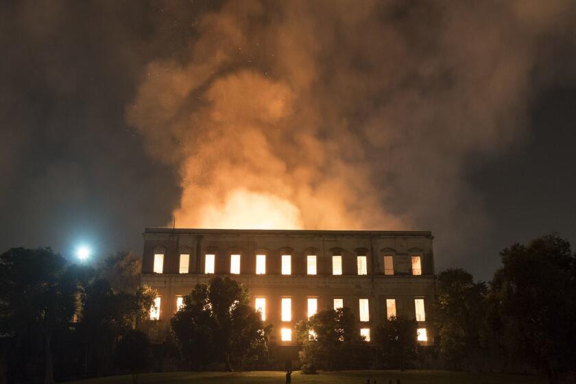 People watch as flames engulf the 200-year-old National Museum of Brazil, in Rio de Janeiro, Sunday, Sept. 2, 2018. According to its website, the museum has thousands of items related to the history of Brazil and other countries. The museum is part of the Federal University of Rio de Janeiro (AP Photo/Leo Correa)