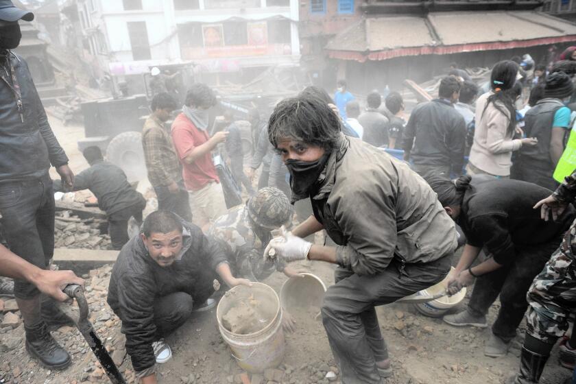 People clear rubble in Katmandu's Durbar Square, a UNESCO World Heritage Site, after the quake.