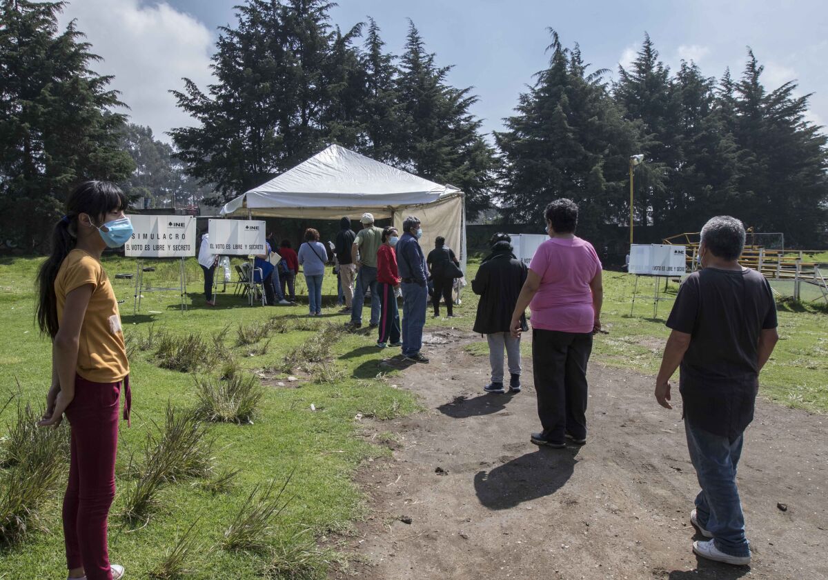 Unas personas se forman para emitir su voto en un referendo, en San Miguel Topilejo, en la Ciudad de México.