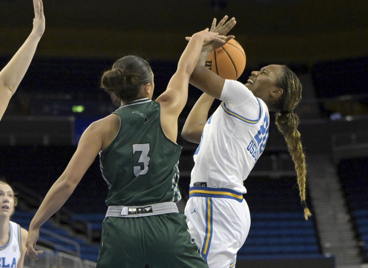 UCLA guard Charisma Osborne, right, shoots over Hawaii guard Ashley Thoms.
