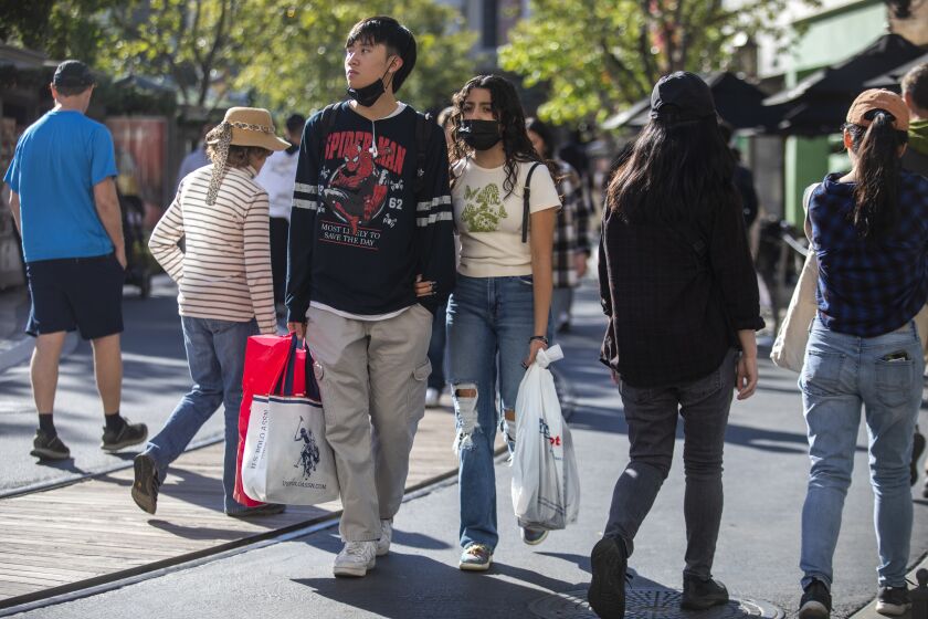 Glendale, CA - November 25: David Huynh, 17, left, and Joanna Marinez, 16, right, both of El Monte, are shopping on Black Friday at The Americana At Brand, Nov. 25, 2022, in Glendale, CA. (Francine Orr / Los Angeles Times)