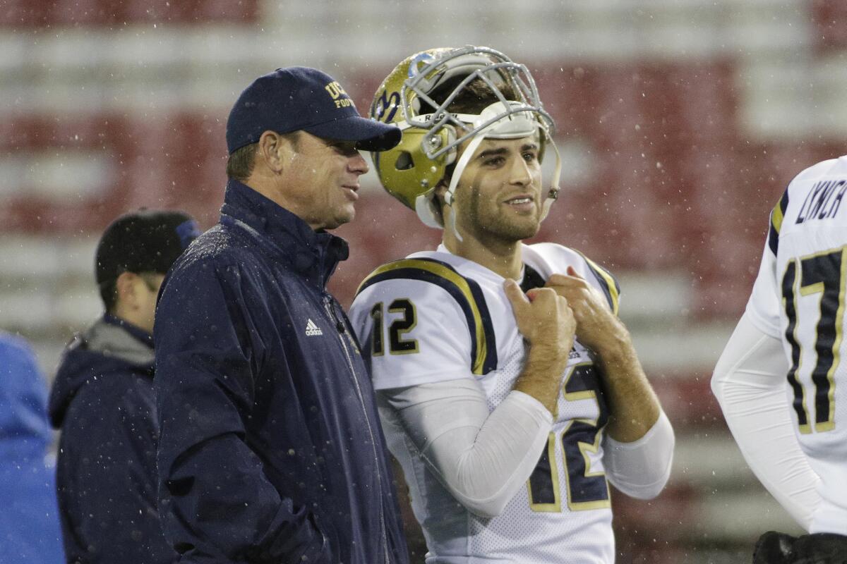 UCLA quarterback Mike Fafaul speaks with Coach Jim Mora before the game against Washington State.