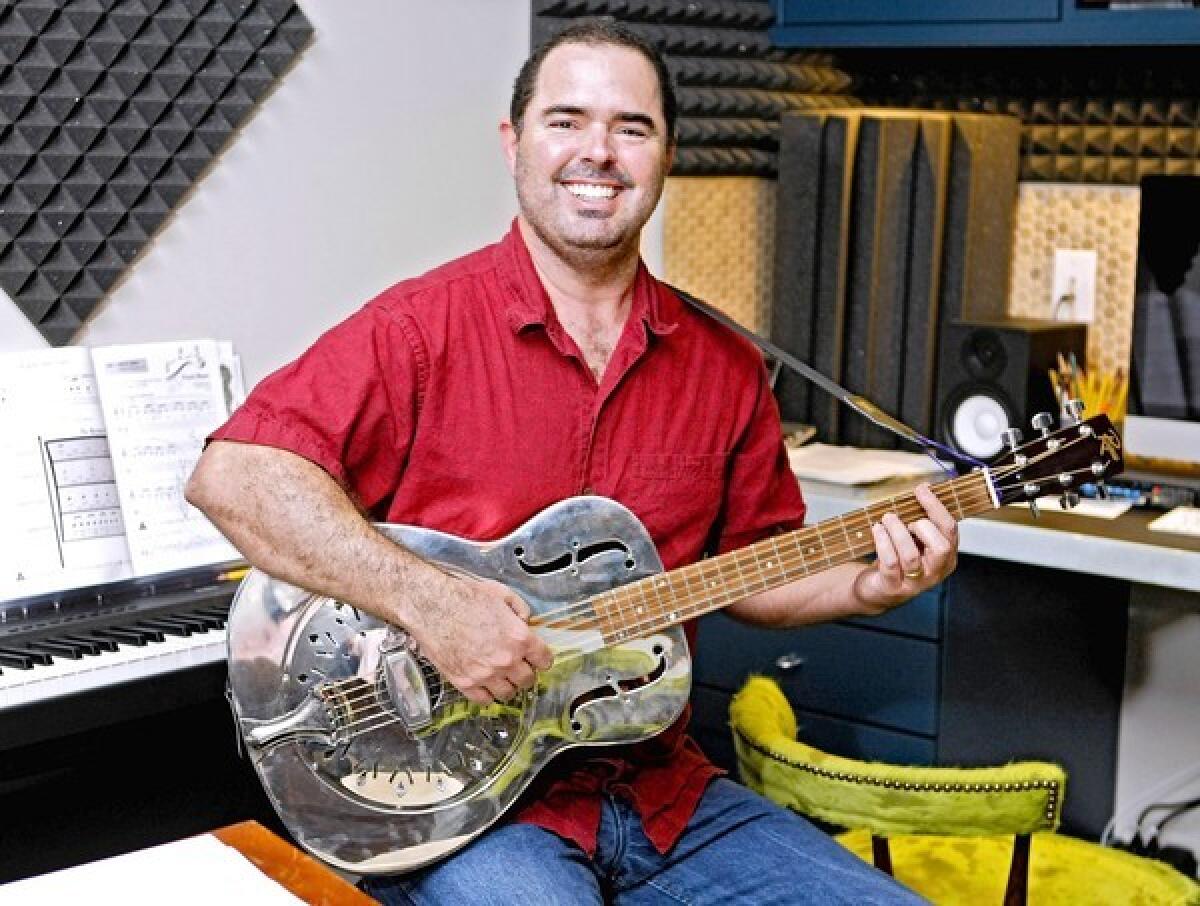 Musician Tim Griffin at his La Cañada Flintridge home office on Tuesday, July 23, 2013. The former educator is offering his educational music free to schools and to parents and children through his non-profit Griffin Education Solutions and website. Griffin does free live shows at schools and also offers free songwriting workshops.