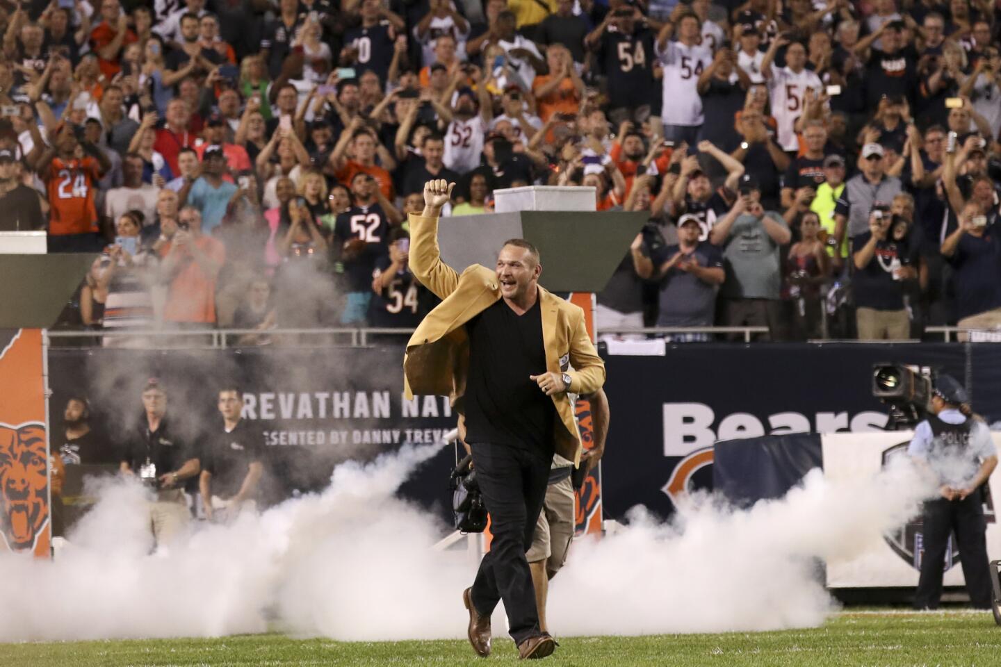 Brian Urlacher runs on the field before being awarded the Hall of Fame Ring of Excellence during halftime of the Bears-Seahawks game at Soldier Field on Sept. 17, 2018.