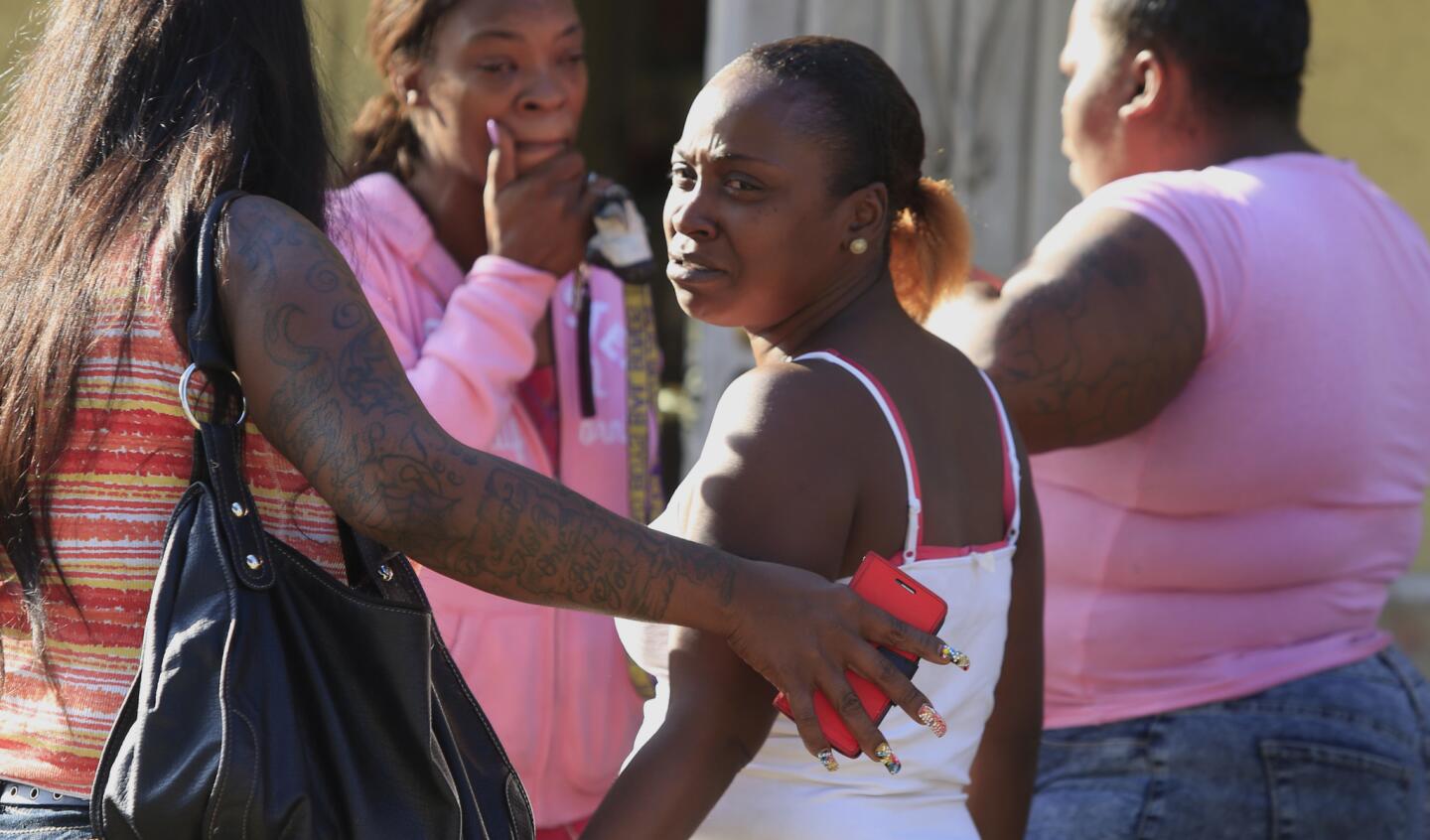Danisha Mitchell, center, is surrounded by friends and family outside her South Los Angeles home a day after her son, 7-year-old Jamarion Thomas, was run over and killed by an ice-cream truck.