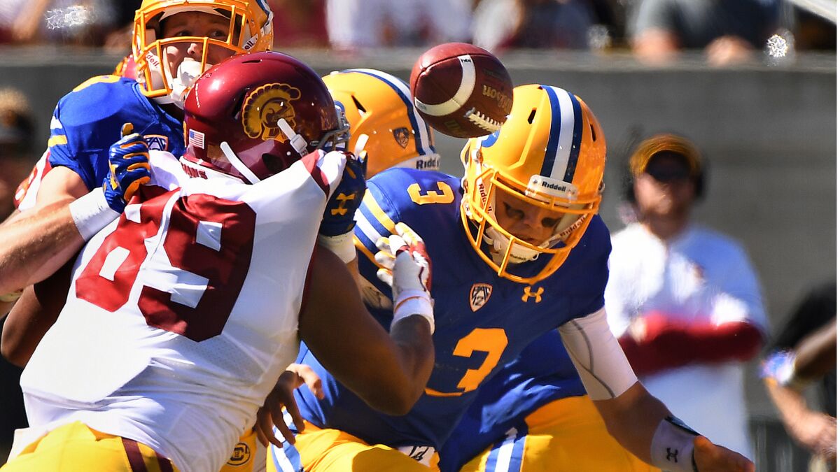 USC defensive lineman Christian Rector forces Cal quarterback Ross Bowers to a fumble during the second quarter.