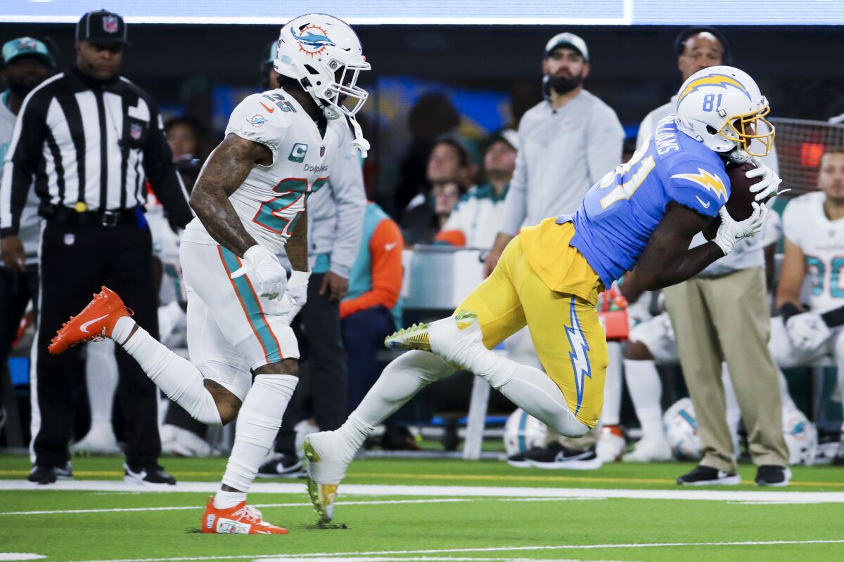 Chargers receiver Mike Williams falls to the turf after catching a pass as  Dolphins cornerback Xavien Howard pursues. 