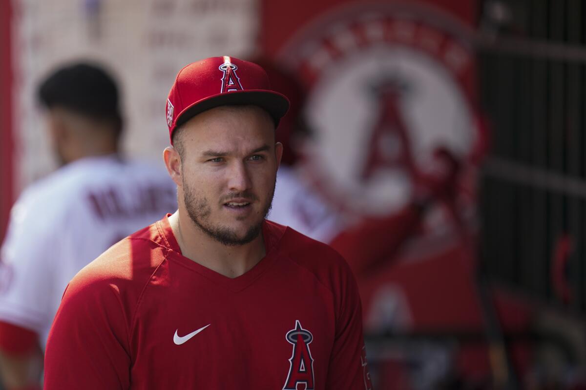 Angels' Mike Trout walks through the dugout during a baseball game.