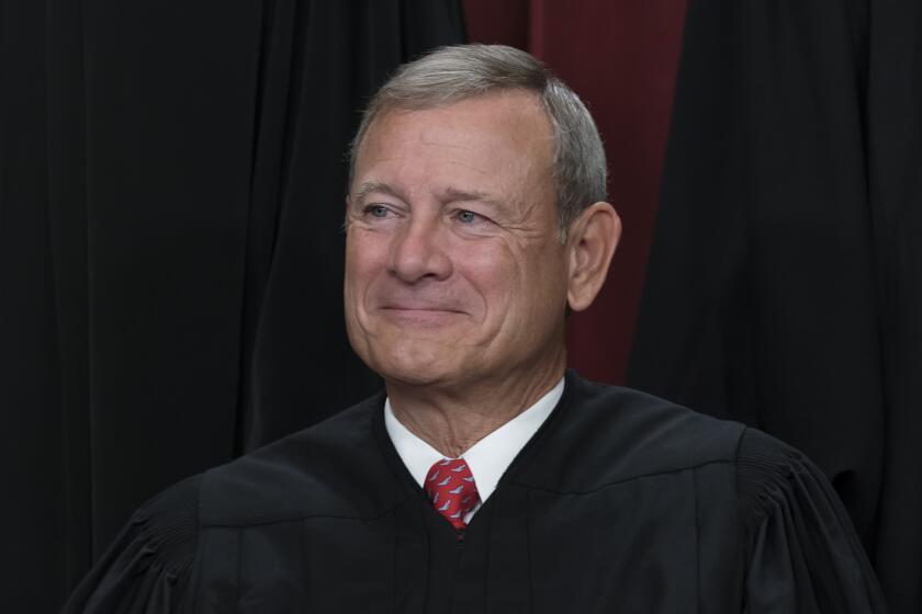 Chief Justice of the United States John Roberts joins other members of the Supreme Court as they pose for a new group portrait, at the Supreme Court building in Washington, Friday, Oct. 7, 2022. Chief Justice Roberts was nominated by President George W. Bush who elevated him to chief justice after the death of Chief Justice William Rehnquist in 2005. (AP Photo/J. Scott Applewhite)