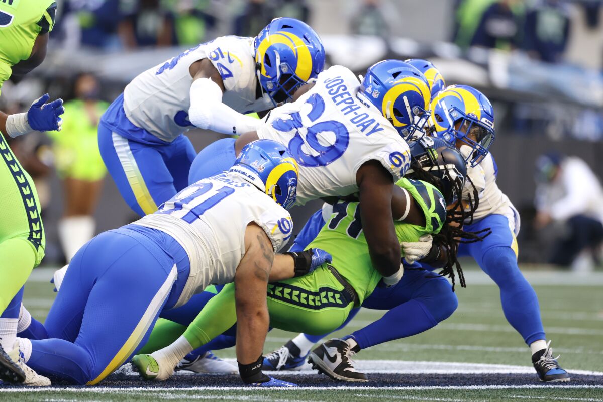 Seattle Seahawks running back Alex Collins is wrapped up by Los Angeles Rams defensive tackle Sebastian Joseph-Day (69) as he rushes during the first half of an NFL football game, Thursday, Oct. 7, 2021, in Seattle. (AP Photo/Craig Mitchelldyer)