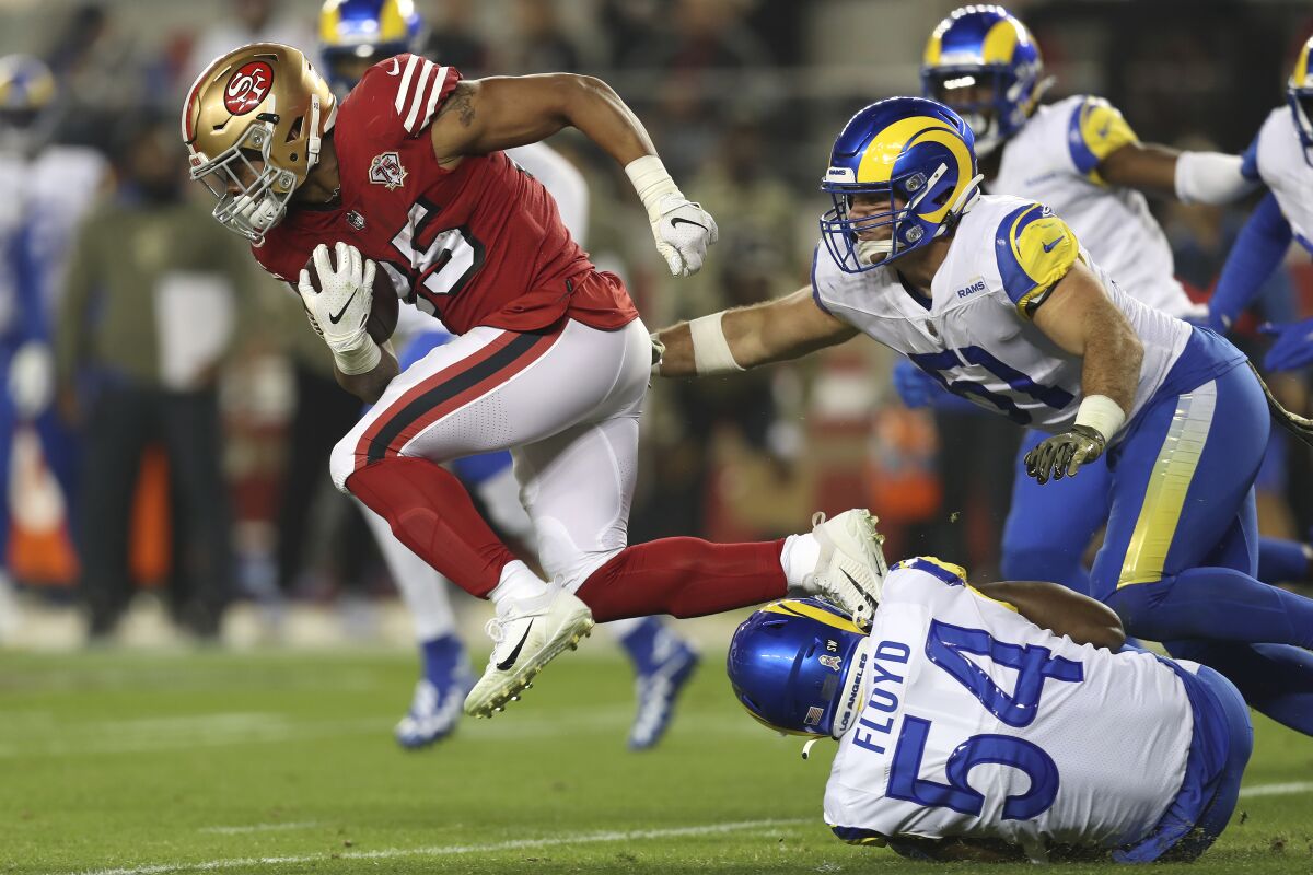 San Francisco's Eli Mitchell runs through the Rams defense.