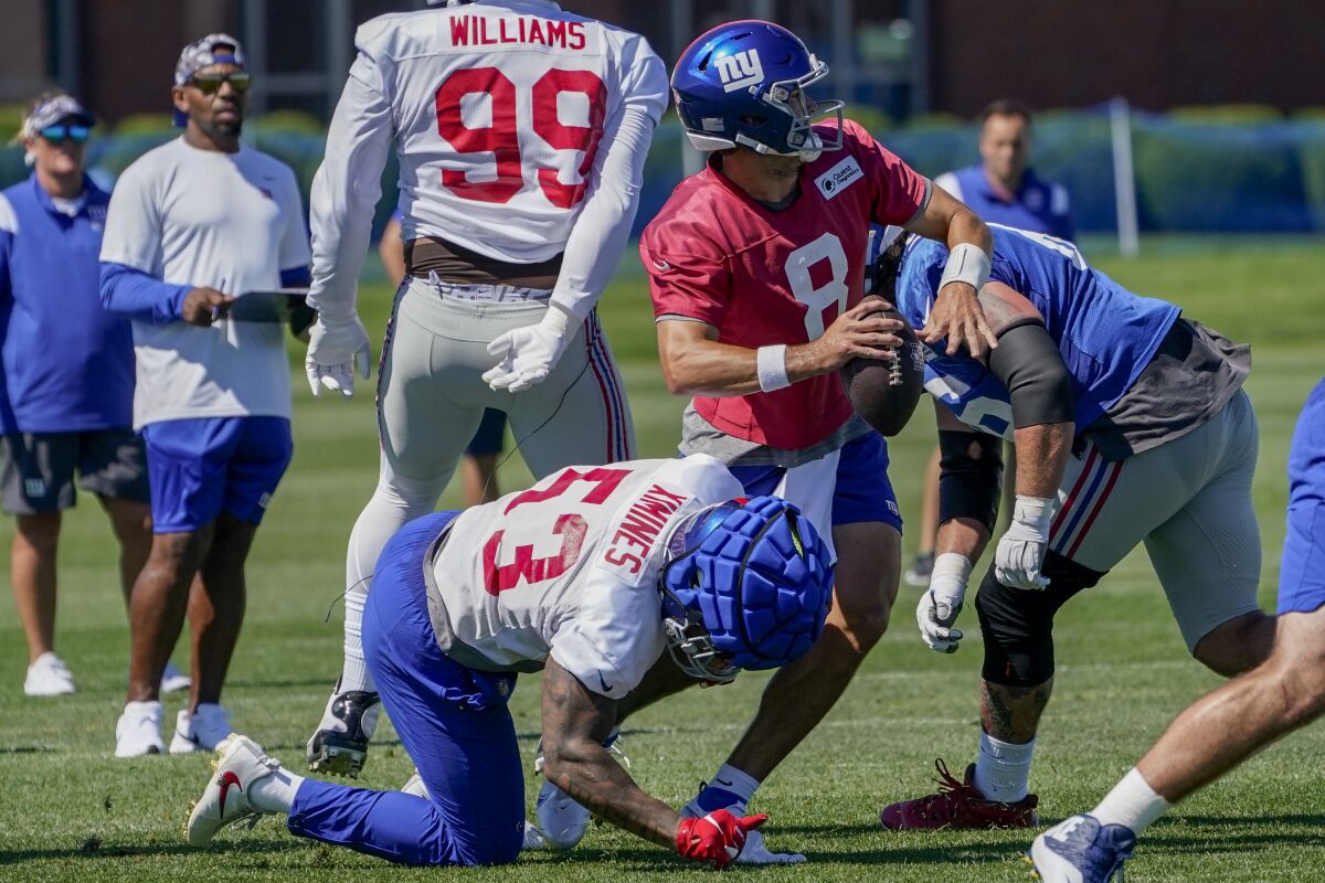 New York Giants quarterback Daniel Jones (8) is sacked on a play by linebacker Oshane Ximines (53) during training camp at the NFL football team's practice facility, Saturday, July 30, 2022, in East Rutherford, N.J. (AP Photo/John Minchillo)