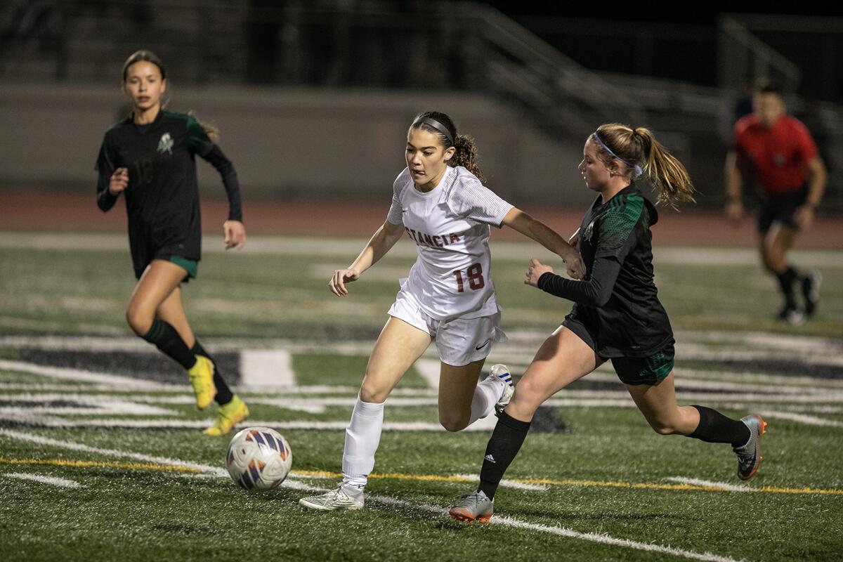 Estancia's Grace Boyce and Costa Mesa's Emiley Davis battle for a ball during Tuesday's Battle for the Bell match.