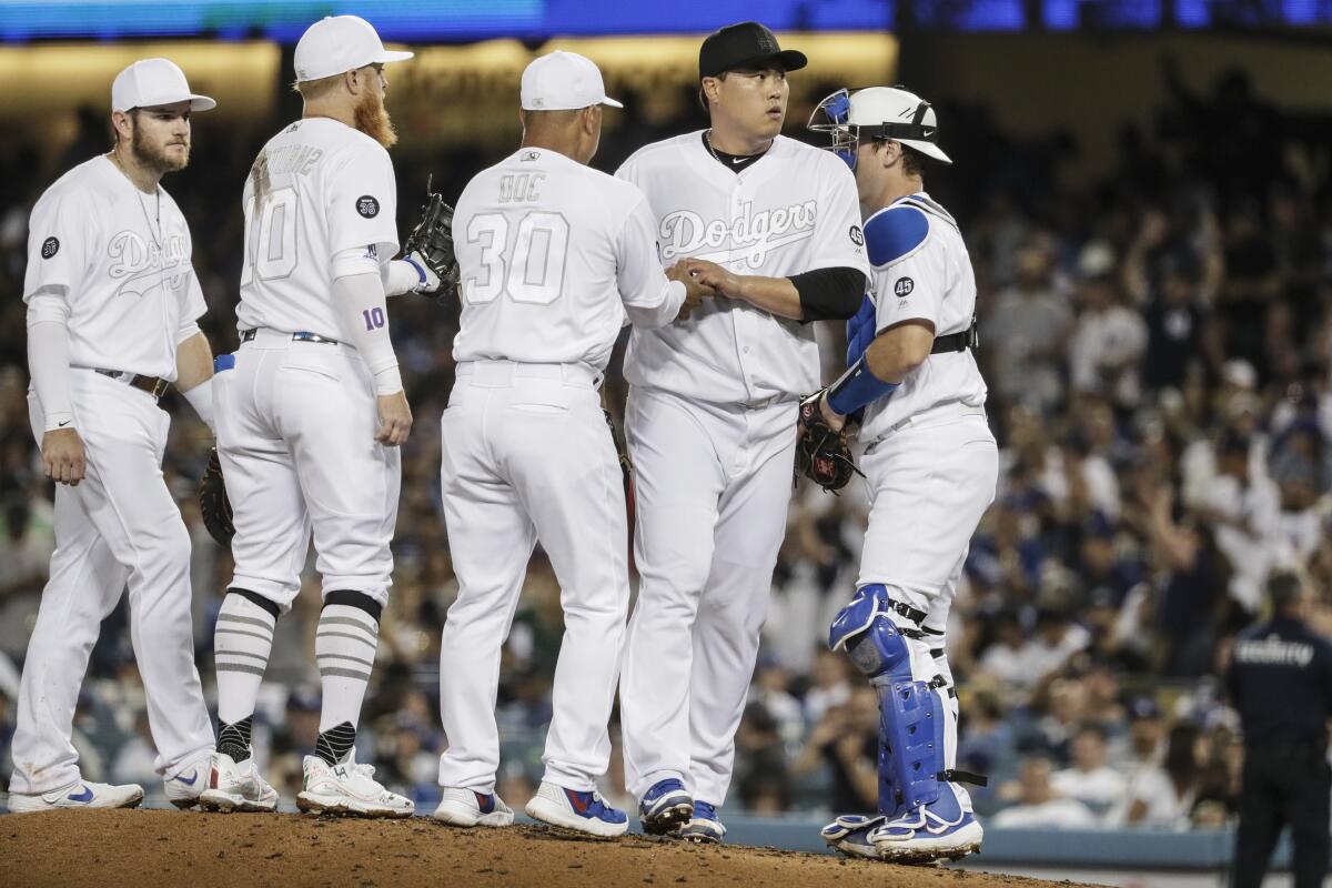 Dodgers manager Dave Roberts takes the ball from starter Hyun-Jin Ryu on Aug. 23, 2019.