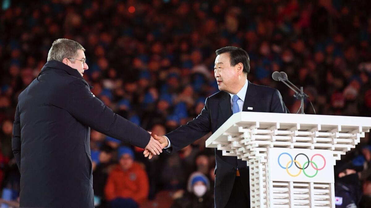 Pyeongchang 2018 organizing committee President Lee Hee-beom, right, shakes hands with IOC President Thomas Bach during the Games' closing ceremony on Feb. 25.