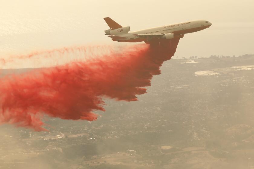 SANTA BARBARA, CA - NOVEMBER 26, 2019 A DC-10 Aircraft makes drops of Phos-Chek fire retardant on the hillsides of the Santa Ynez Mountains above Santa Barbara where homes are located along Painted Cave Road as the Cave Fire which has burned over 4,000 acres continues to burn without containment on Tuesday. (Al Seib / Los Angeles Times)