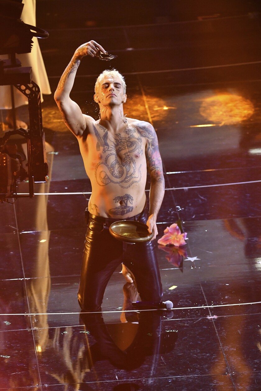 Achille Lauro performs what was called a “profane” faux baptism as he sings "Domenica" at the San Remo music festival in Sanremo, Italy, Tuesday, Feb. 1, 2022. An Italian bishop on Wednesday, Feb. 2, 2022, strongly protested the performance, denouncing both the singer and RAI state television for showing a “profane” faux baptism on stage. (Matteo Rasero/LaPresse via AP)