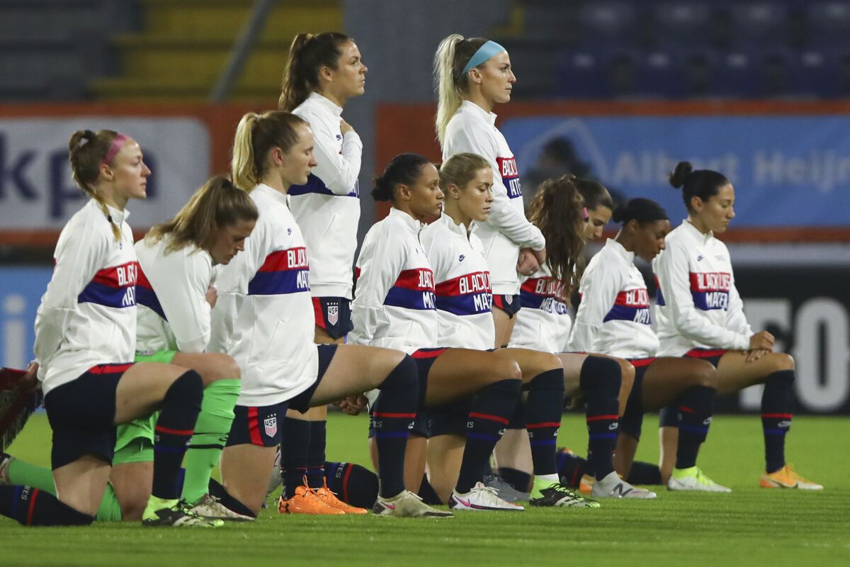 FILE - United States players wear a sweater with the slogan "Black Lives Matter" and most take the knee as the national anthem is played prior to the international friendly women's soccer match between The Netherlands and the US at the Rat Verlegh stadium in Breda, southern Netherlands, on Nov. 27, 2020. The unions for the U.S. women’s and men’s national teams have not committed to agreeing to a single pay structure, the head of the U.S. Soccer Federation said in a letter to fans Tuesday, Jan. 11, 2022. (Dean Mouhtaropoulos/Pool via AP, File)