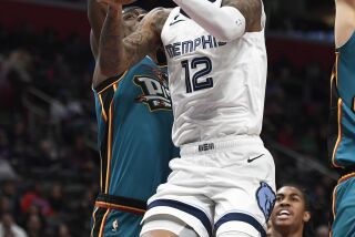 El base de los Grizzlies de Memphis Ja Morant salta hacia la canasta superando al pívot de los Pistons de Detroit Jalen Duren en el encuentro del domingo 4 de diciembre del 2022. (AP Foto/Jose Juarez)