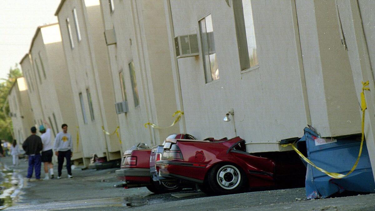 Crushed cars sit underneath a collapsed apartment building in the 19100 block of Victory Boulevard after the 1994 Northridge earthquake.