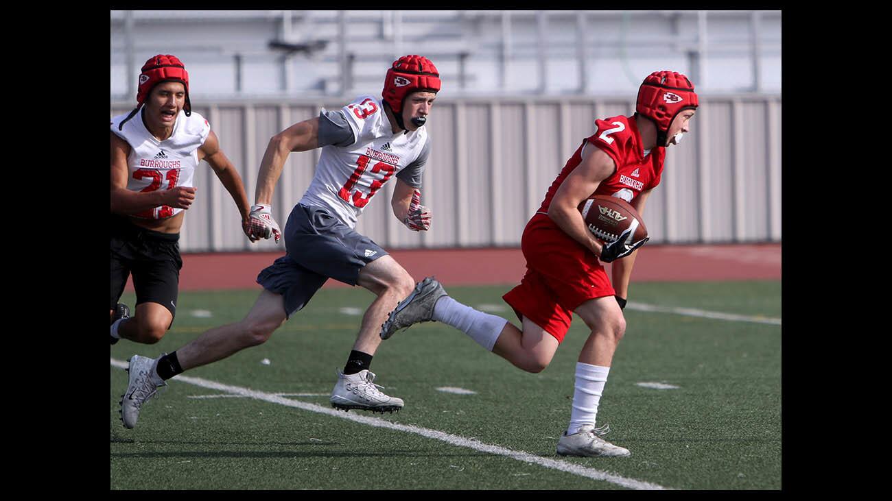 Burroughs High School football player #2 Nathan Turner is chased down by #13 Kyle Heymen during inter-squad football game, at Memorial Field in Burbank on Friday, May 18, 2018.