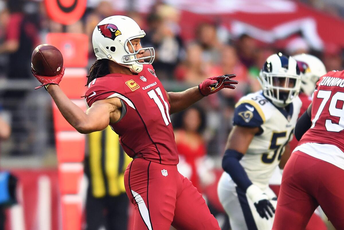 Arizona Cardinals wide receiver Larry Fitzgerald throws a touchdown pass against the Rams in the second quarter at State Farm Stadium on Sunday in Glendale, Ariz.