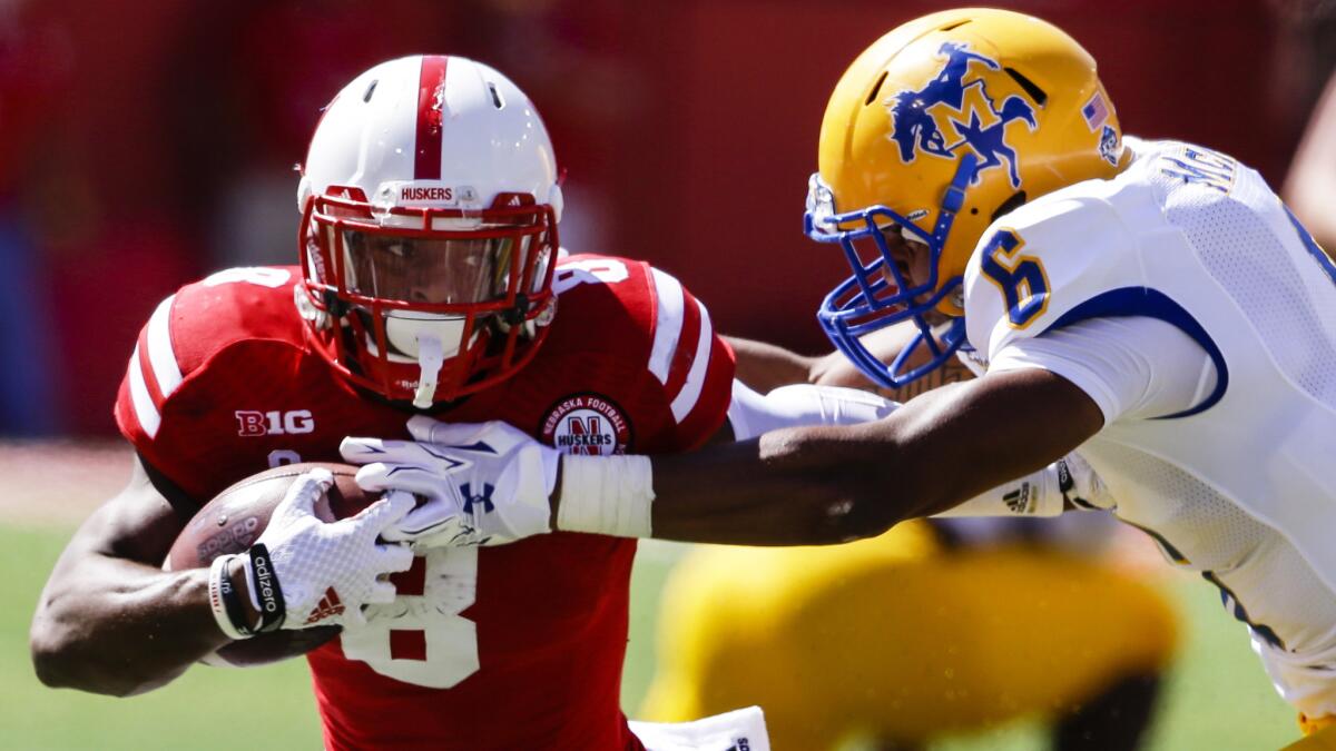 Nebraska running back Ameer Abdullah, left, tries to break a tackle by McNeese State defensive back Brent Spikes during the first half of the Cornhuskers' 31-24 comeback victory Saturday.