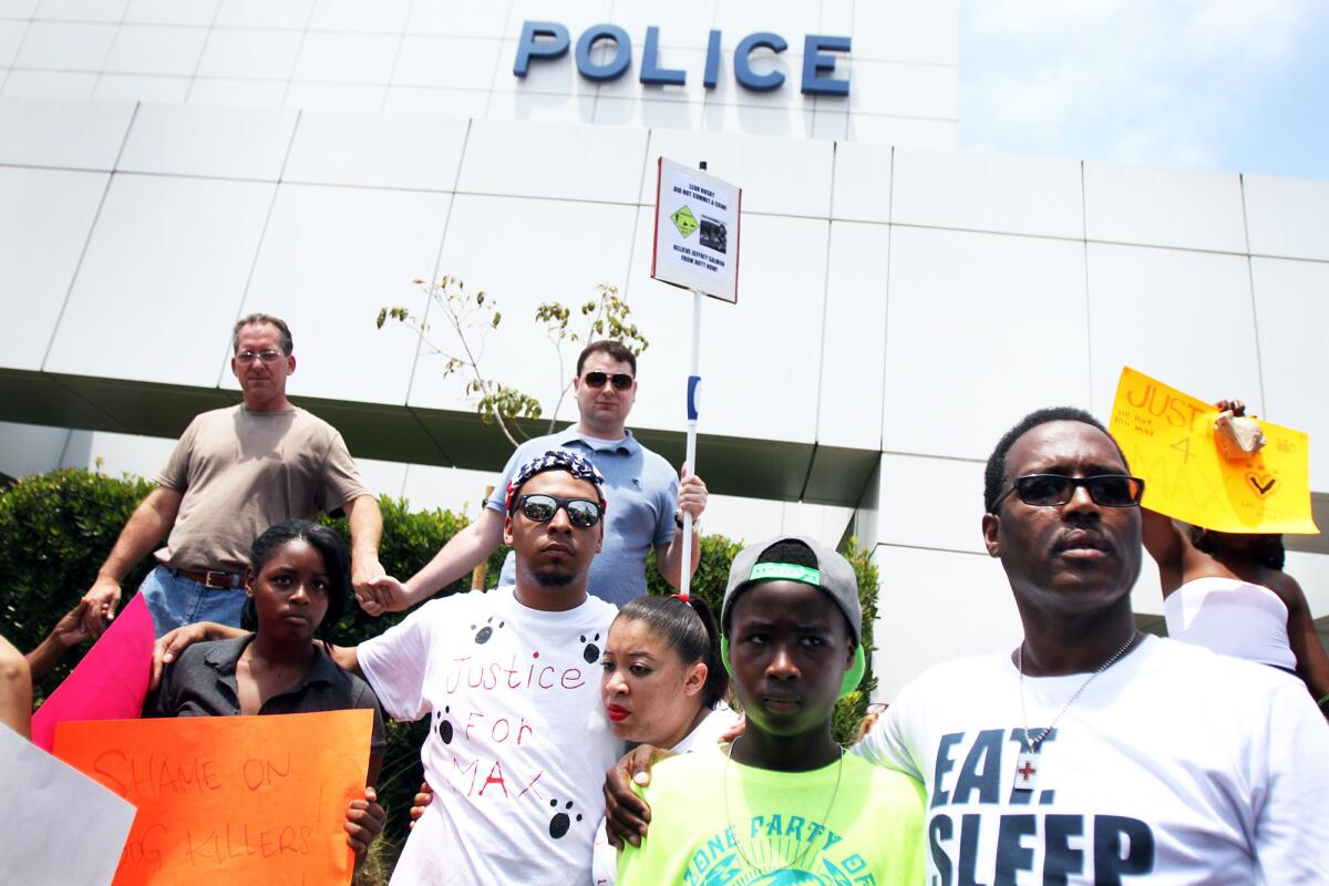 Leon Rosby embraces his son, Joshua, 12, as they pray during a protest at the Hawthorne Police Department on July 6, 2013. Rosby's Rottweiler was shot and killed by officers.